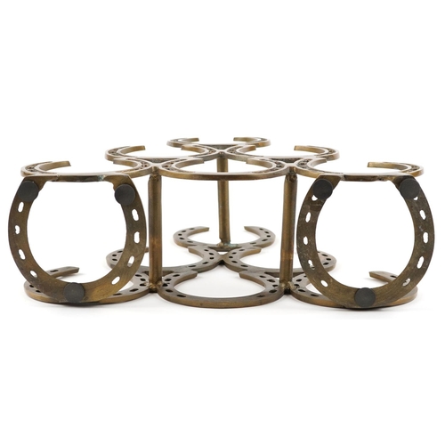 1563 - A bronzed six place wine rack in the form of horseshoes, 40cm high.