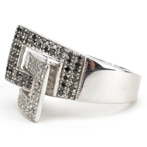 3029 - A Modernist 9ct white gold cluster ring set with black and white diamonds, size J/K, 5.4g.