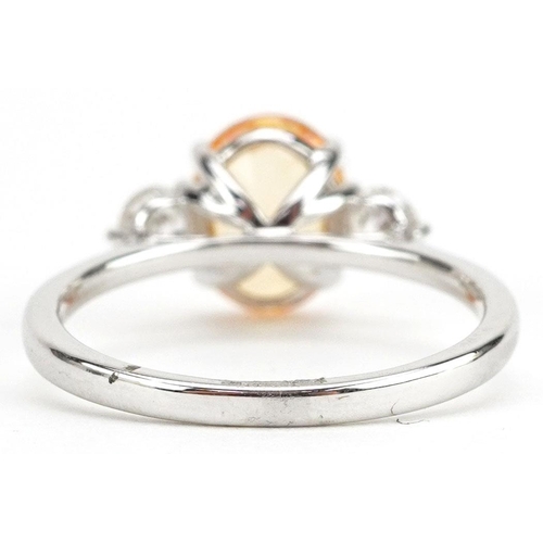 3037 - An 18ct white gold orange sapphire and diamond three stone ring, the sapphire approximately 2.22 car... 