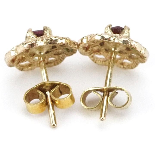 3060 - A pair of pierced 9ct gold garnet solitaire stud earrings, 9mm in diameter, total 1.6g.