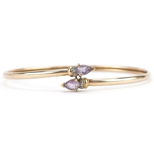 3071 - A 9ct gold amethyst teardrop and diamond bangle, 6.5cm wide, 4.6g.