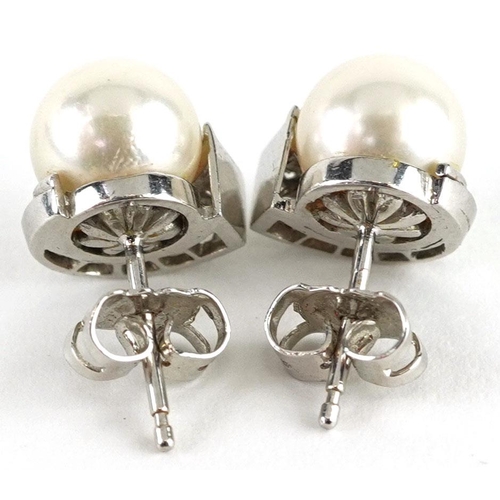 3015 - A pair of unmarked white gold cultured pearl and diamond stud earrings, the pearls 8.2mm in diameter... 