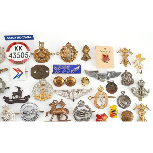 2471 - A mixed group of military badges and buttons to include a silver ARP cap badge, some reproductions.