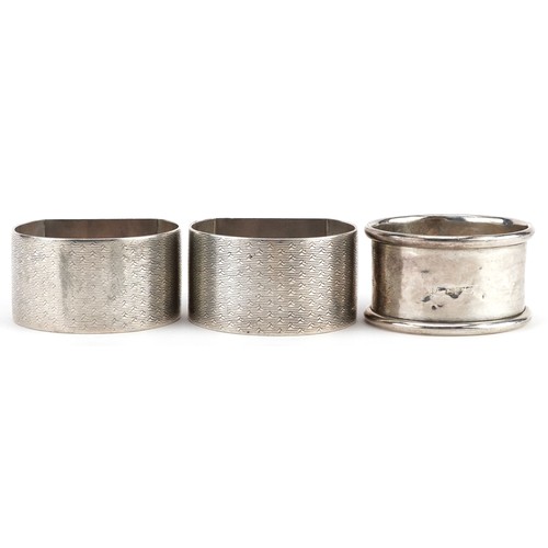 476 - A pair of silver George V napkin rings with engine turned decoration, Birmingham 1930, worn marks, t... 