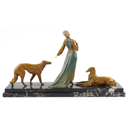  Roggia - A French Art Deco bronze and painted figure group of a lady with two dogs on a black marble... 