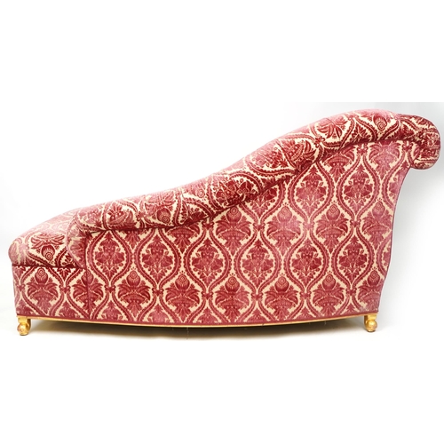 1048 - A 20th century Victorian style scroll arm chaise lounge upholstered in a red and cream velor, on gil... 