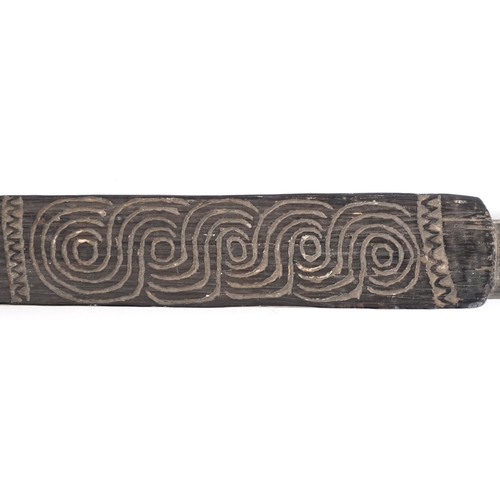 334 - An African ceremonial ebonised spear carved with motifs, 192cm in length.