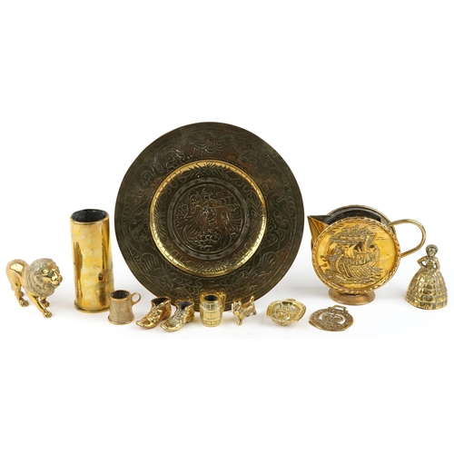 1301 - A small collection of 20th century brassware to include a charger, shell casing and a jug.