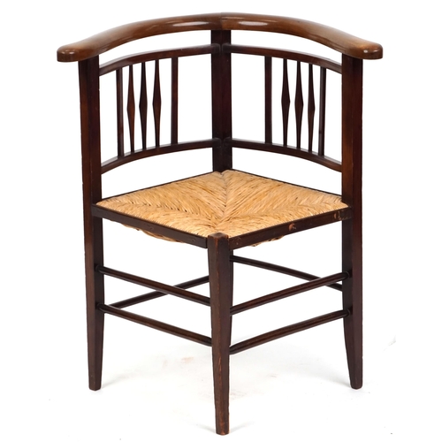 1051 - An early 20th century Arts & Crafts style mahogany corner armchair with rush seat, 72cm high x 62cm ... 