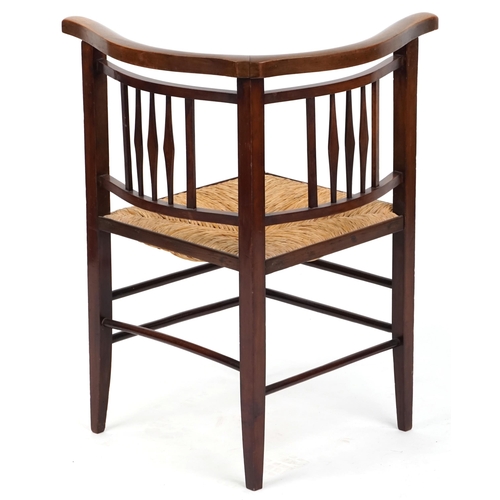 1051 - An early 20th century Arts & Crafts style mahogany corner armchair with rush seat, 72cm high x 62cm ... 