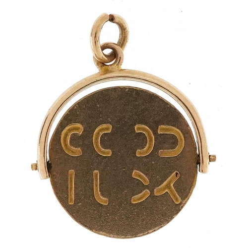 393 - A 9ct gold Good Luck spinner charm, 1.6cm high, 1.1g.