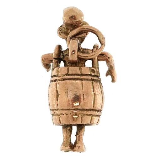  A 9ct gold charm in the form of a man in a barrel, 1.8cm high, 2.4g.