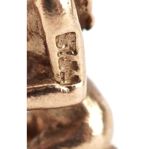  A 9ct gold charm in the form of a kneeling nude female holding flowers, 2cm high, 3.0g.