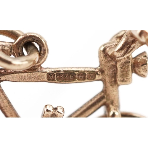  A 9ct gold charm in the form of a bicycle with rotating wheels, 2.1cm in length, 1.8g.