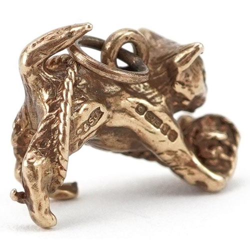 410 - A 9ct gold charm in the form of a cat with a ball of yarn, 1.5cm in length, 2.5g.