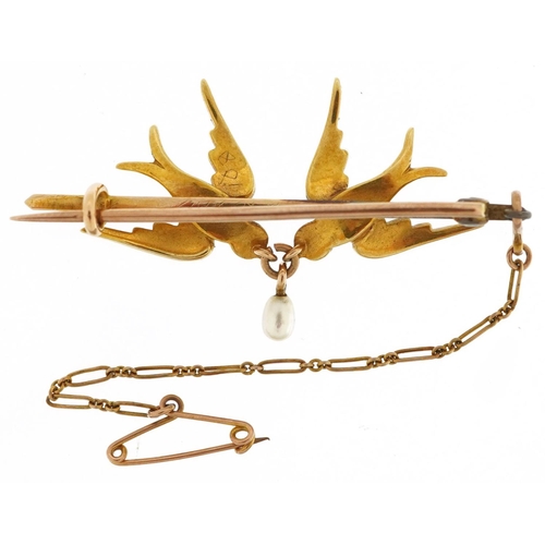  An Edwardian unmarked gold bar brooch in the form of two swallows set with seed pearls, housed in a ... 