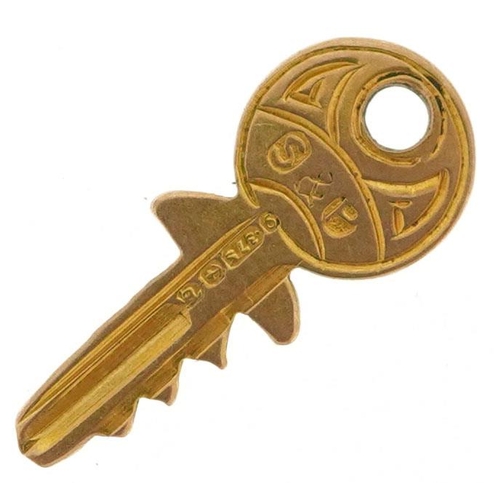 593 - A 9ct gold charm in the form of a key, 1.5cm high, 0.3g.