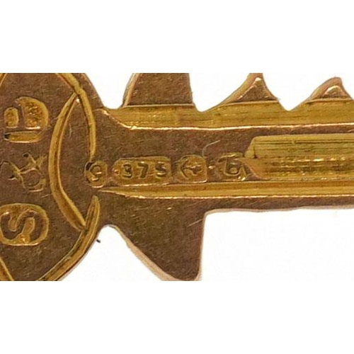 593 - A 9ct gold charm in the form of a key, 1.5cm high, 0.3g.