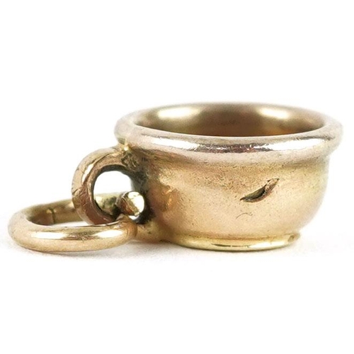 604 - An unmarked gold charm in the form of a chamber pot, 1.1cm in length, 1.2g.