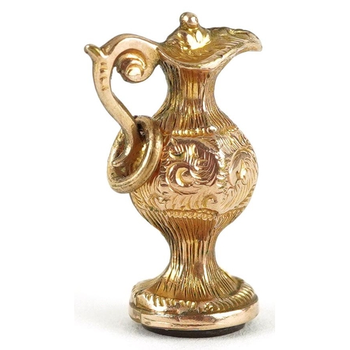 288 - A 9ct gold charm in the form of a wine ewer with carnelian base, 2cm high, 1.9g.