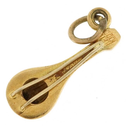 578 - A 9ct gold charm in the form of a mandolin, 1.5cm in length, 1.0g.