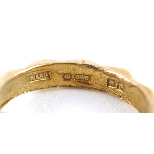 600 - A 9ct gold charm in the form of an engagement ring and wedding ring, 1.6cm high, 1.6g.