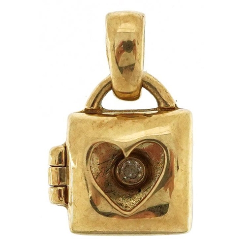 583 - A 9ct gold love heart handbag charm opening to reveal a diamond, 1.4cm high, 1.1g.