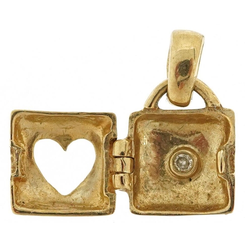 583 - A 9ct gold love heart handbag charm opening to reveal a diamond, 1.4cm high, 1.1g.