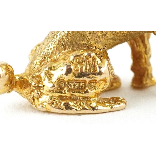 128 - A 9ct gold charm in the form of a seated Poodle, 2.0cm high, 6.5g.