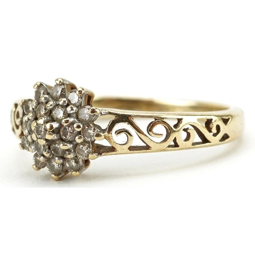 136 - A 9ct gold diamond three tier flower head ring with pierced shoulders, size N, 2.1g.