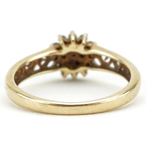 136 - A 9ct gold diamond three tier flower head ring with pierced shoulders, size N, 2.1g.