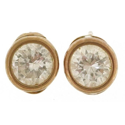 594 - A pair of 9ct gold clear stone solitaire stud earrings, 7.0mm in diameter, total 1.1g.