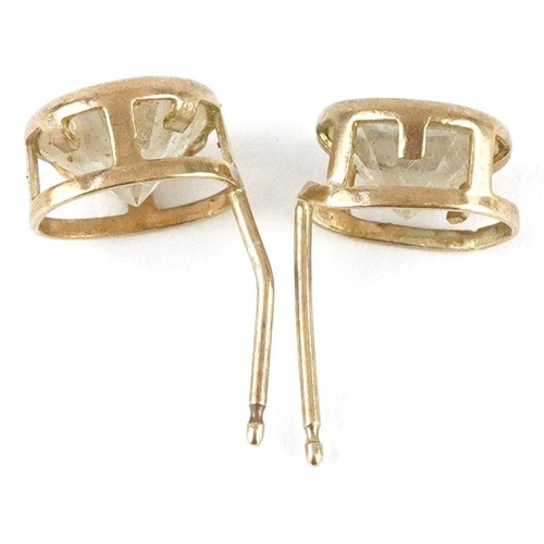 594 - A pair of 9ct gold clear stone solitaire stud earrings, 7.0mm in diameter, total 1.1g.