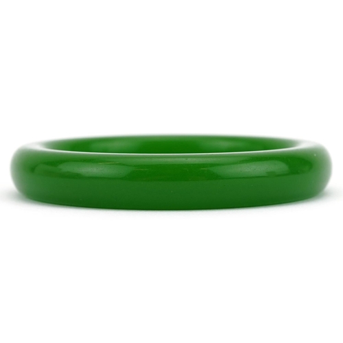 322 - A Chinese style green stone bangle, 8cm in diameter, 60.2g.