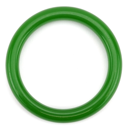 322 - A Chinese style green stone bangle, 8cm in diameter, 60.2g.