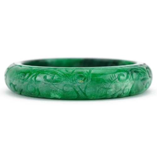 163 - A Chinese green hardstone bangle with engraved decoration, 7cm in diameter, 64.0g.