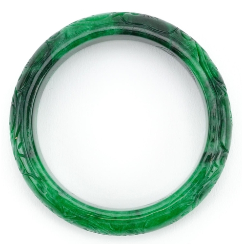 163 - A Chinese green hardstone bangle with engraved decoration, 7cm in diameter, 64.0g.