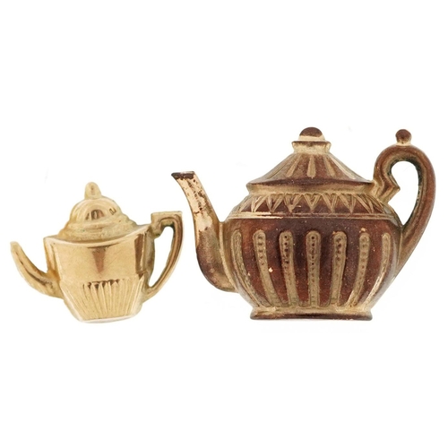 382 - Two 9ct gold charms in the form of teapots, the largest 2.4cm wide, total 2.8g.