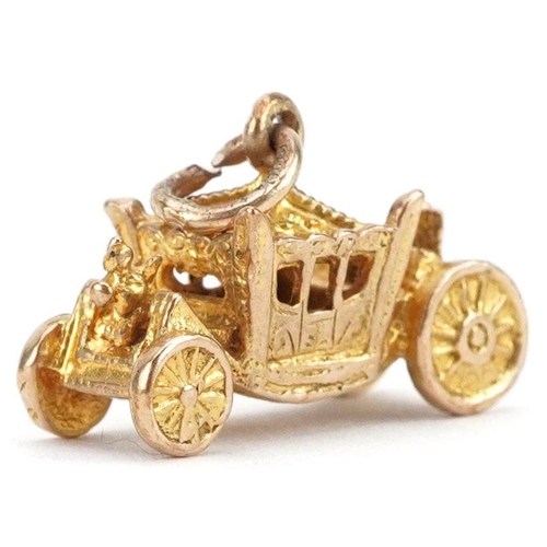  A 9ct gold charm in the form of the coronation coach, 1.8cm wide, 2.9g.