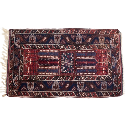 1070 - A Kurdish rug, mid 20th century, the blue field with three central stylized columns within a complem... 