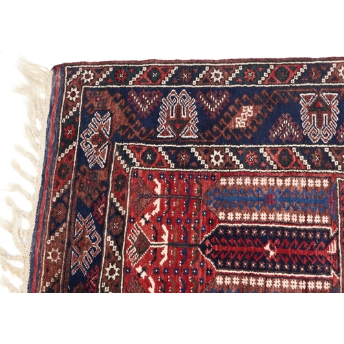 1070 - A Kurdish rug, mid 20th century, the blue field with three central stylized columns within a complem... 