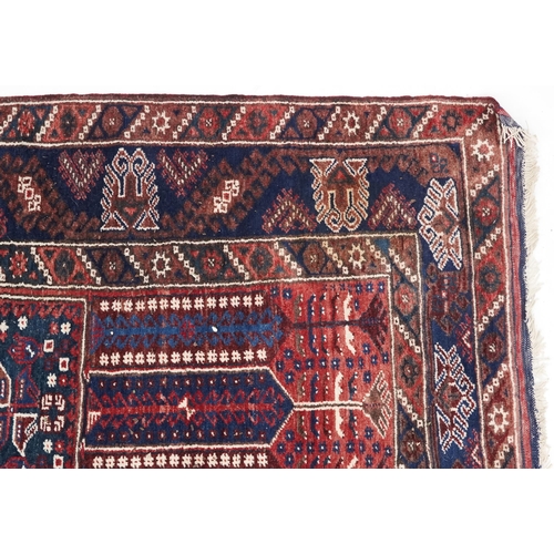 1070 - A Kurdish rug, mid 20th century, the blue field with three central stylized columns within a complem... 