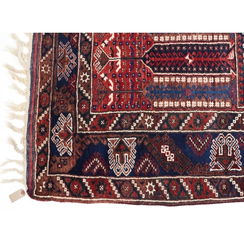 1070 - A Kurdish rug, mid 20th century, the blue field with three central stylized columns within a complem... 