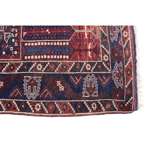 1070 - A Kurdish rug, mid 20th century, the blue field with three central stylized columns within a complem... 