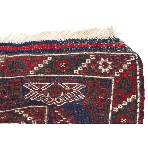 1070 - A Kurdish rug, mid 20th century, the blue field with three central stylized columns within a complem... 