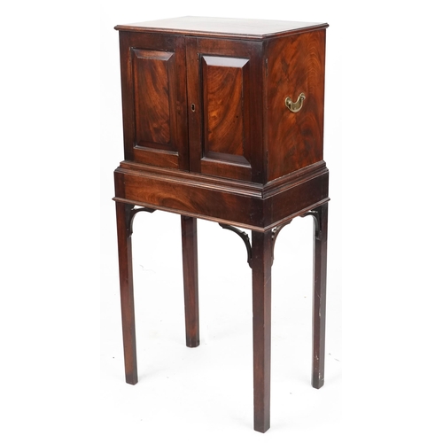 A George III figured mahogany collector's cabinet on stand, the panelled doors revealing eight drawers with brass pulls, raised on block legs, 123cm H x 58cm W x 38cm D.