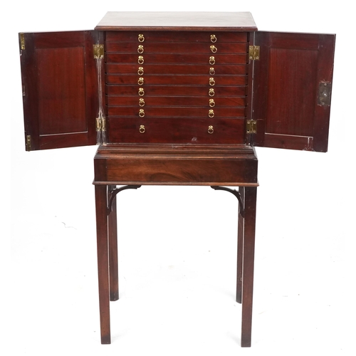 1002 - A George III figured mahogany collector's cabinet on stand, the panelled doors revealing eight drawe... 