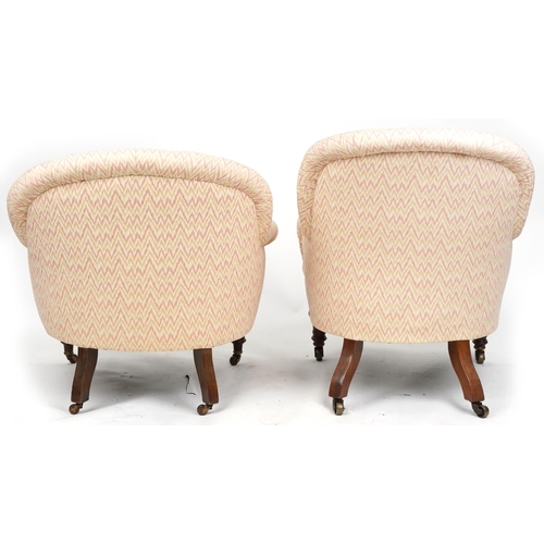 1008 - Two similar Victorian tub back armchairs raised on turned legs and castors,  87cm high x 69cm wide.