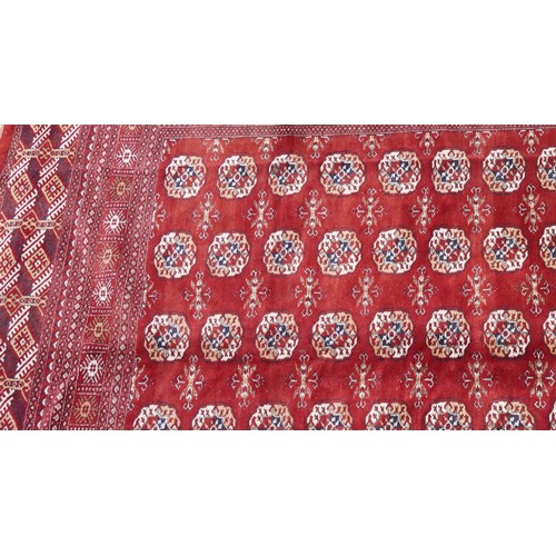  A Pakistan Bokhara carpet, late 20th century, the red field with six central columns of guls within ... 