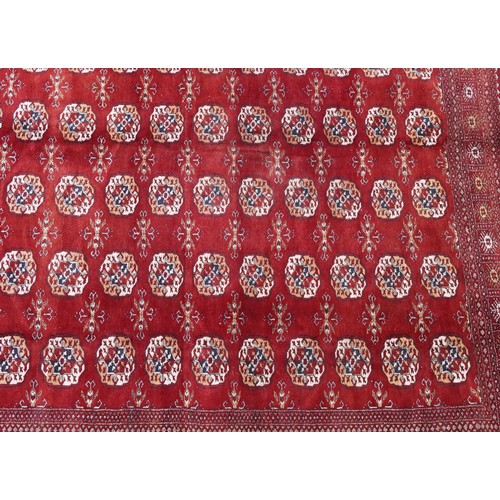  A Pakistan Bokhara carpet, late 20th century, the red field with six central columns of guls within ... 